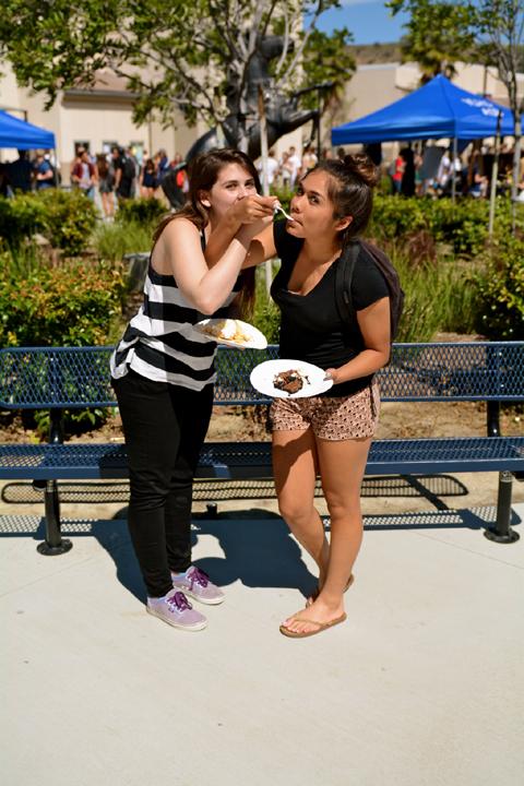 Alexis Rangel and Erin Vitelli feeding pie friendly to each other