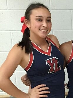 Emelia Ortiz posing in her JV cheer uniform before a game. 