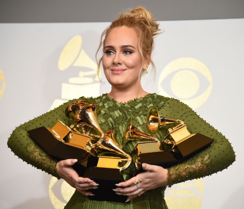 Adele poses on the red carpet with her 5 Grammy awards.