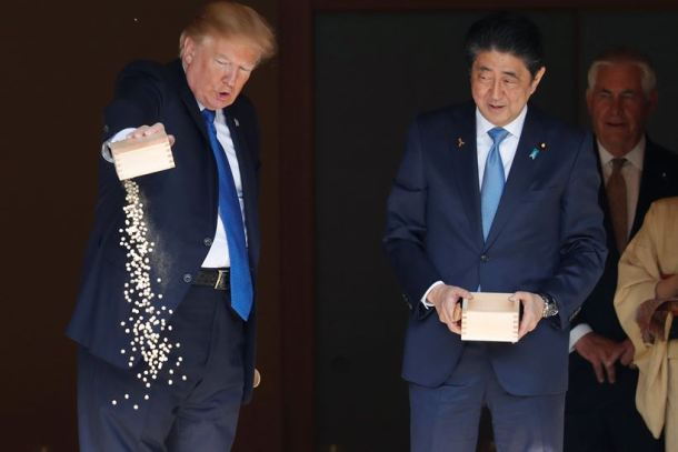Trump feeding Koi fishes with President Shinzo Abe. Photo credit: The Indian Express