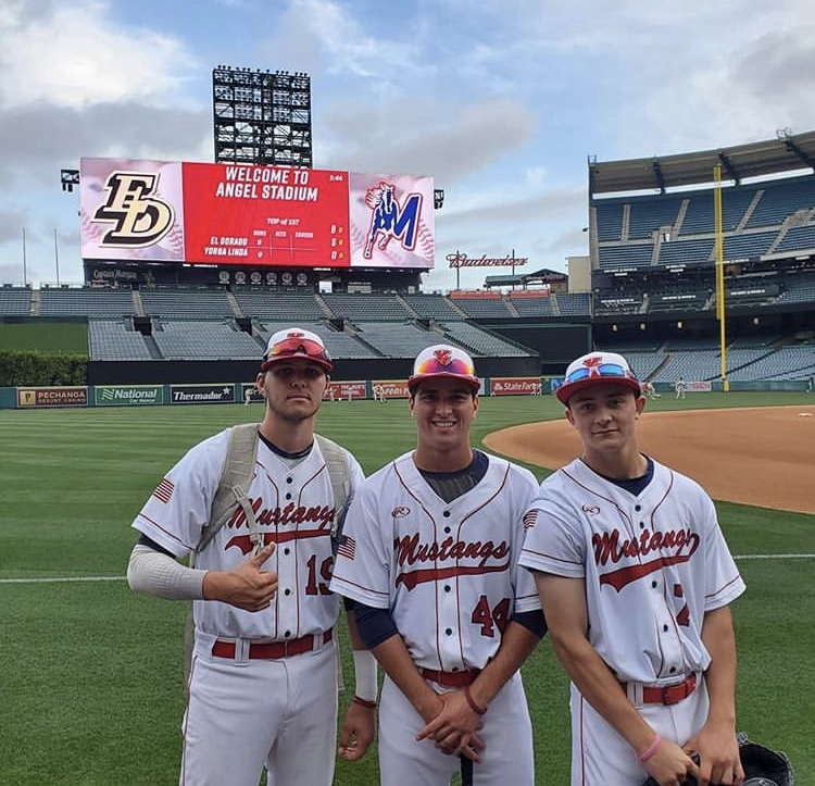 Players from the baseball team pose proudly in front of the Welcome to the Angel Stadium sign. 