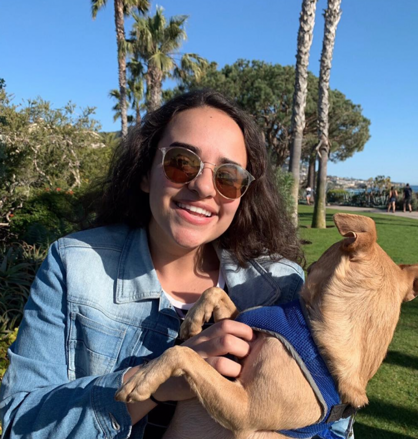 Senior Amina Abdelbary poses with one of her two dogs during one of their walks at the beach.
