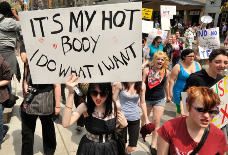 An image taken from a protest in which a woman writes, Its my hot body, I do what I want. 