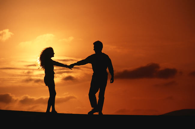 A cute date setting with two people dancing into the sunset.