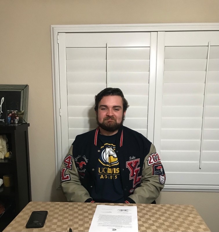 Luke Roncevich poses in front of his letter after he completed committing to play football at UC Davis.