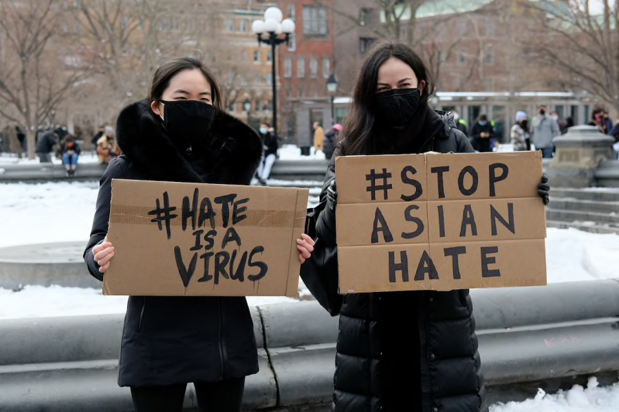 Protestors hold up signs in response to recent Asian hate crimes. 