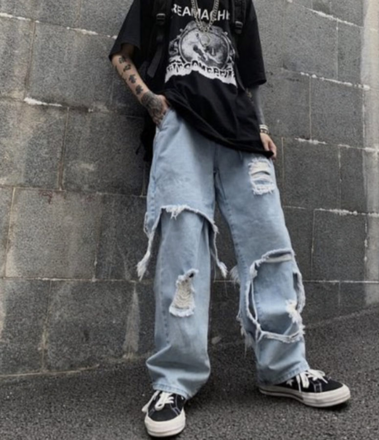 A photo of a grunge outfit consisting of an oversized black t-shirt and large, baggy pants. 
