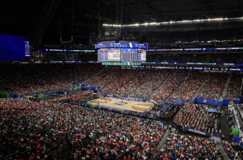 A crowd of thousands of people gather for March Madness, a famous college basketball tournament. Tickets cost $230 and the game is sponsored by big names like Gatorade and Toyota.
