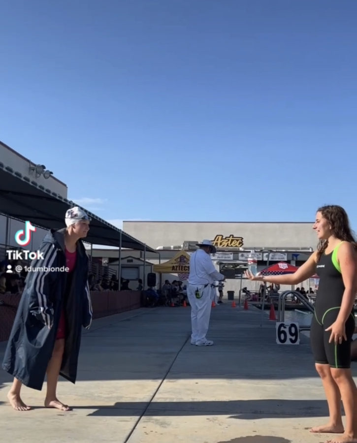 Two people wearing a tech suit during swim finals.