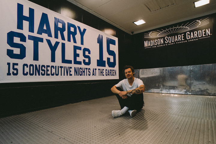 Harry+Styles+sits+in+front+of+his+newly-awarded+banner+at+Madison+Square+Garden.