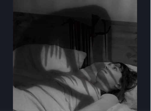 An eerie shadow figure hovers over a girl during sleep paralysis