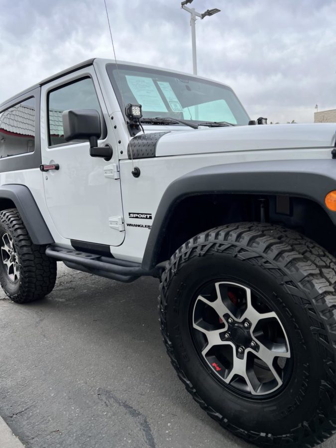 A used Jeep Wrangler is depicted above for sale at a car dealer in Los Angeles.