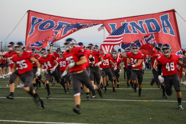 The football team running out for their game against Simi Valley (38-21 W).

