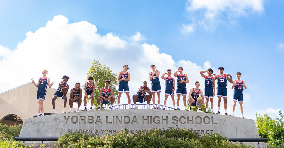 Yorba Linda Mens basketball team having some fun together up on the school sign. 