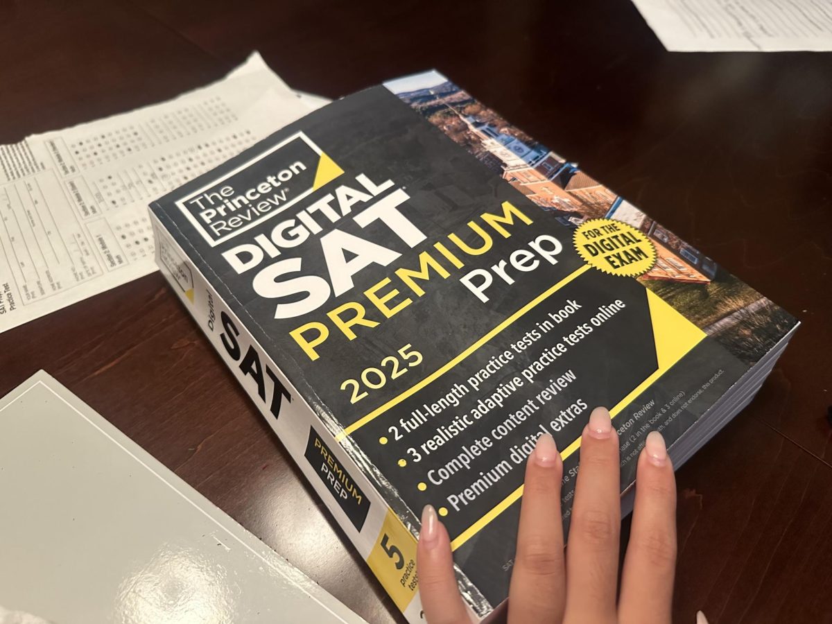 A student  stares at an SAT book, contemplating whether or not they should open it and study.