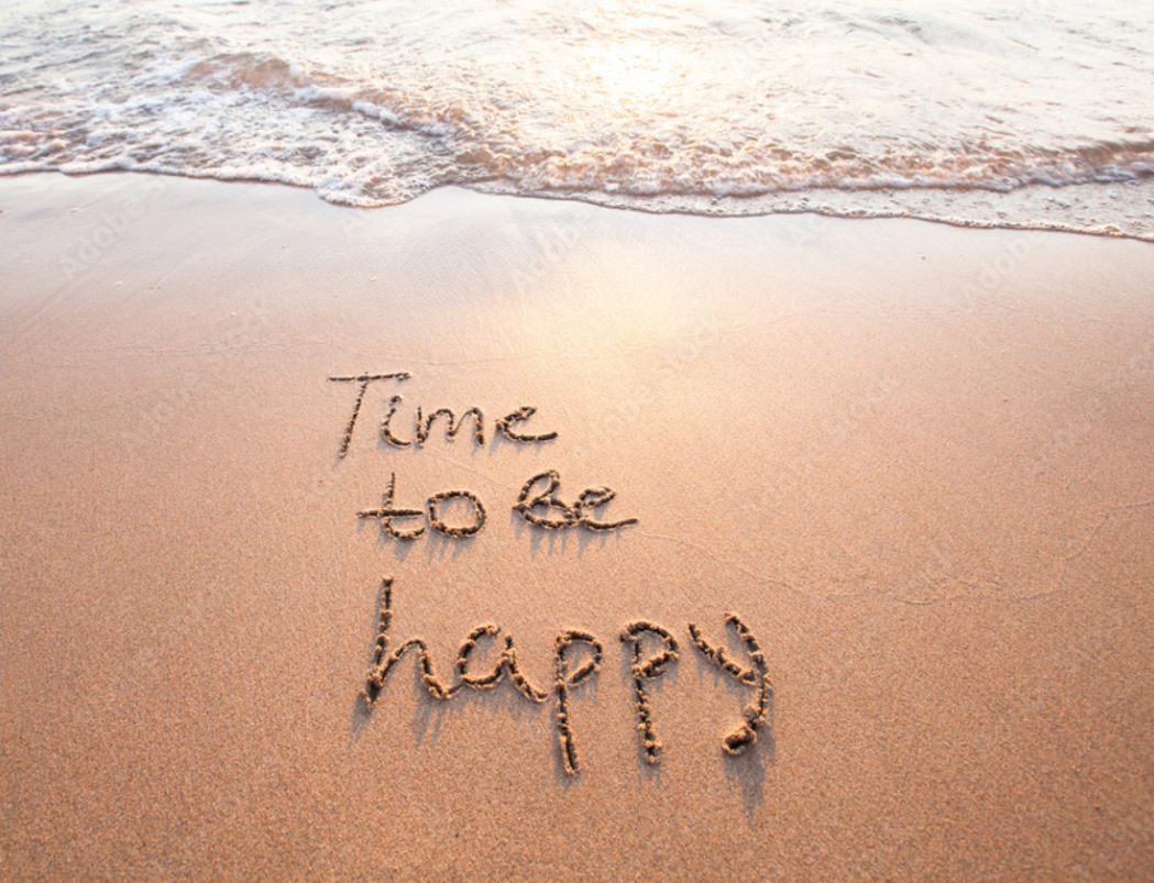 "Time to be happy" engraved in the sand, acting as a symbol of the science behind happiness. 