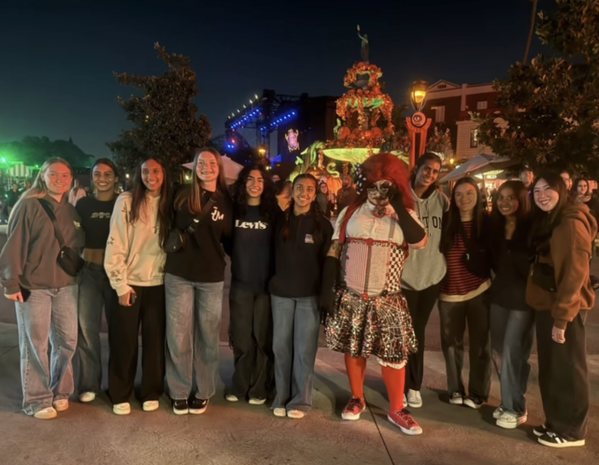 The Yorba Linda Girls' basketball team at Knott's Scary Farm took a picture with a clown at the CARNEVIL scare zone on the Boardwalk.