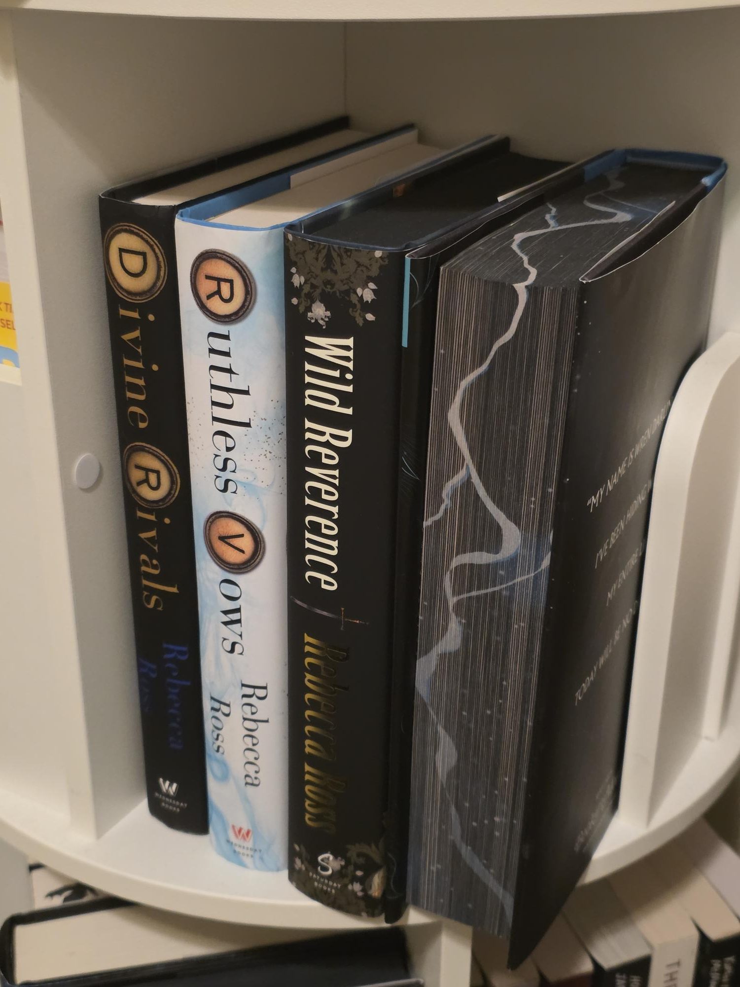 The spines of Divine Rivals, Ruthless Vows, and Wild Reverence by Rebecca Ross. The first two books have typewriter keys in their titles, alluding to the importance of typewriters in their stories.
