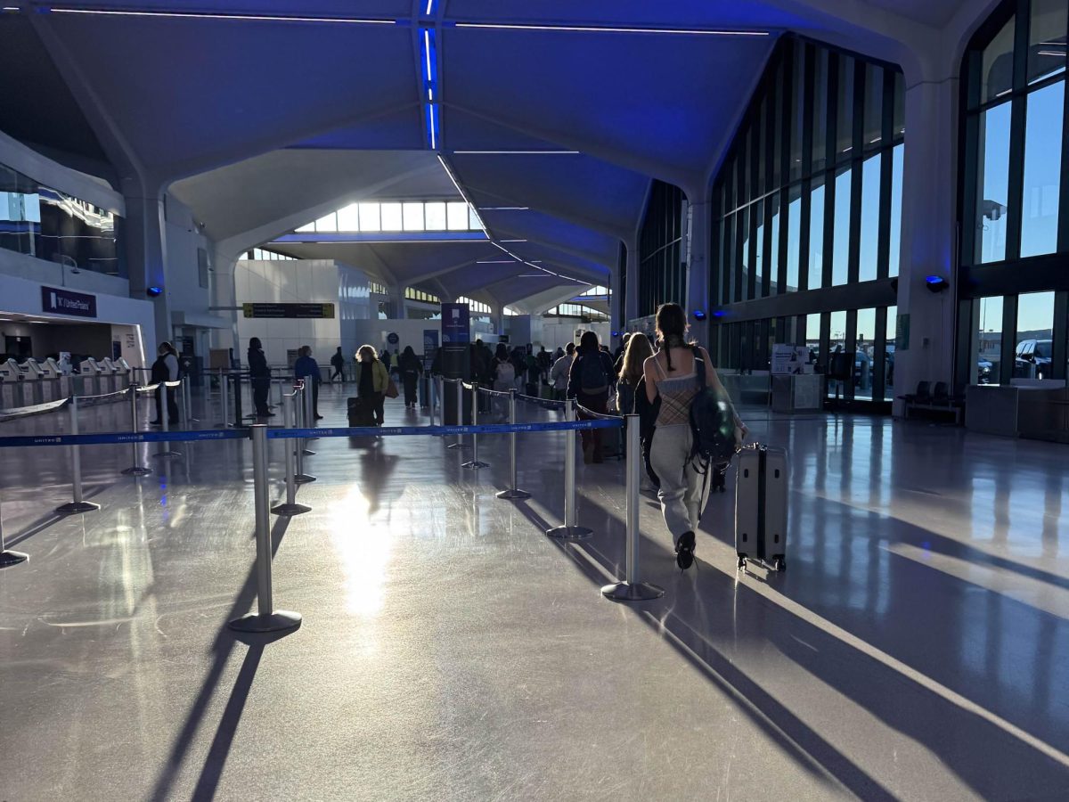 Students make their way toward the baggage check-in counter at the airport.