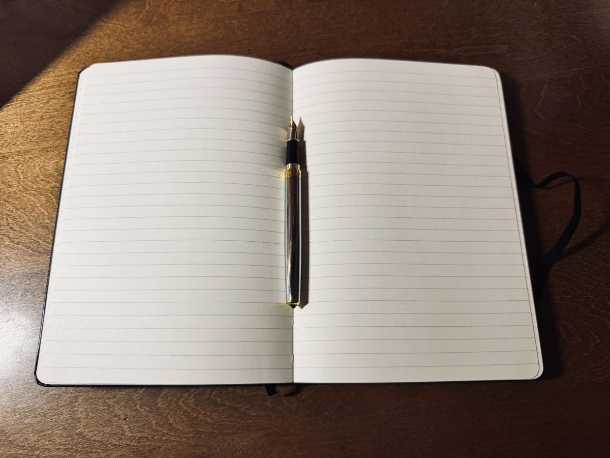 A blank page and pen capture the quiet moment before a story begins.