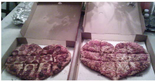 Two heart-shaped pizzas sit on the table on Valentine’s Day, ready to be eaten.