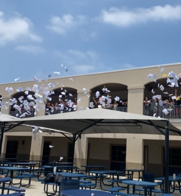 Seniors throwing papers during a campus tradition, capturing a moment of realization following the college decision season. 